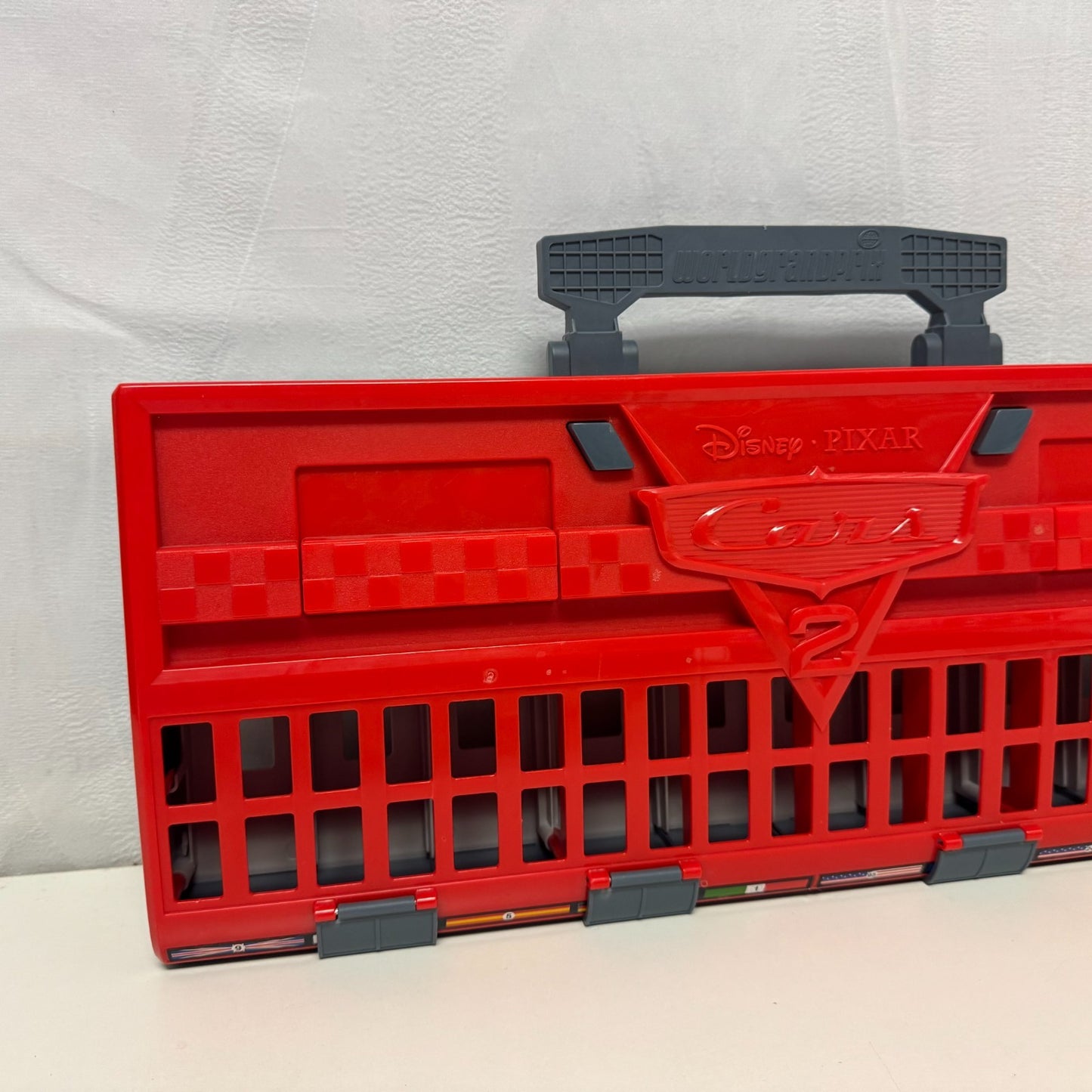 Disney Pixar Cars - WORLD GRAND PRIX RACE LAUNCHER CARRY CASE CARS 2- 1:55 Scale